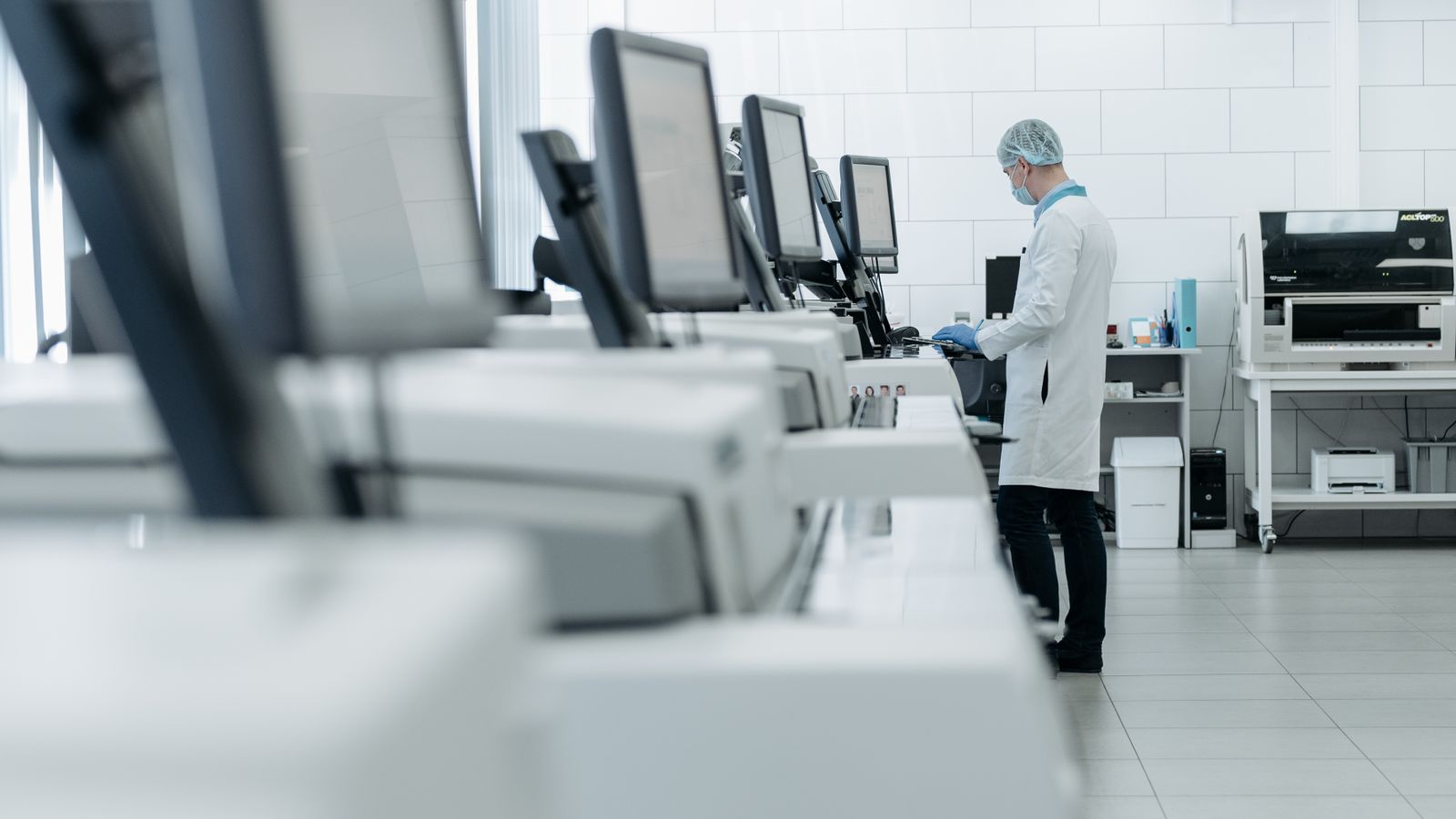 A medical professional in a modern laboratory operating advanced research equipment.