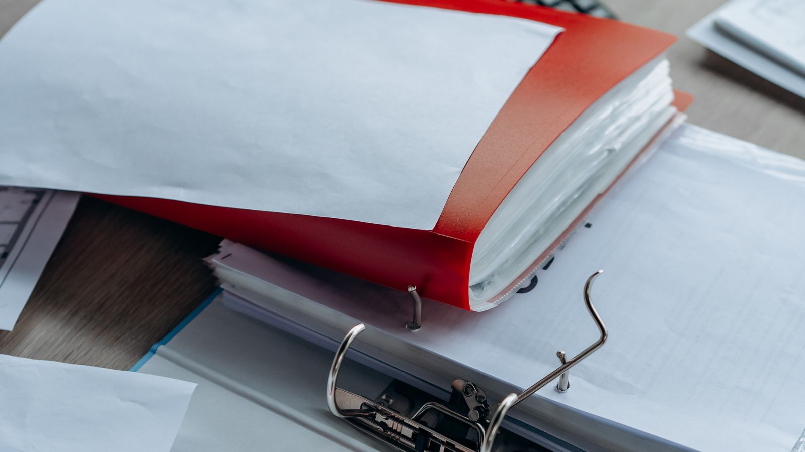 A tidy office desk with organized binders, papers, and stationery arranged neatly.